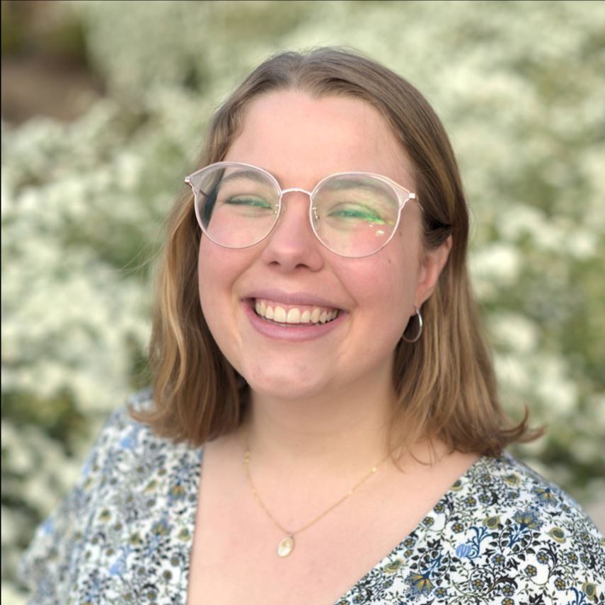 Zoë Johnston Zoë Johnston - young woman with shoulder-length light brown hair, wearing glasses and a flower print v-neck shirt